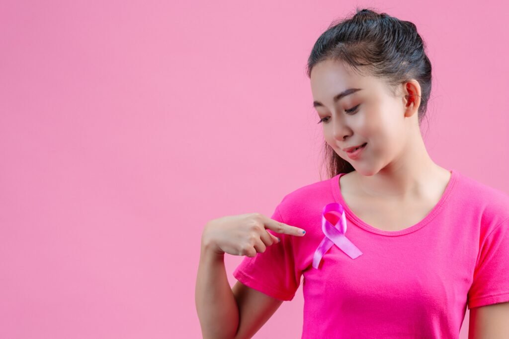 Woman wearing pink t-shirt pointing to pink ribbon symbolizing breast cancer awareness – Dr. Shasanka Das, breast cancer specialist in Kolkata